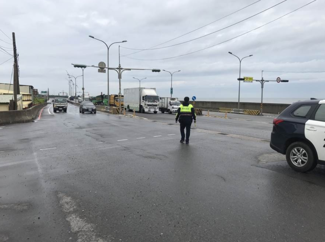 林口警在西濱道路上不畏豪雨員警急拉封鎖線，疏導車輛遠離淹水路段